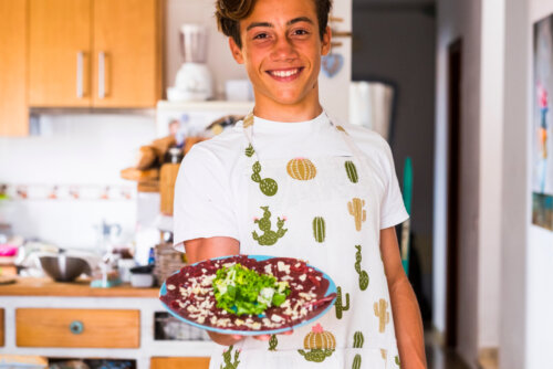 Chico adolescente cocinando con gusto.