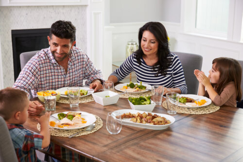 Familia comiendo en casa gracias a los consejos para planificar un menú saludable.