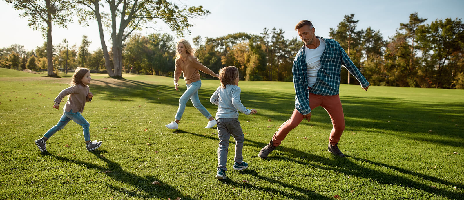 Familia corriendo al aire libre teniendo en cuenta la importancia del juego libre para el desarrollo de sus hijos.