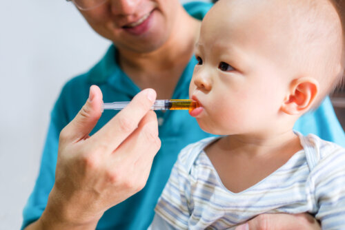 Padre aprendiendo a dar un medicamento a su hijo.