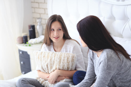 Madre hablando con su hija para evitar conflictos con adolescentes durante la cuarentena.