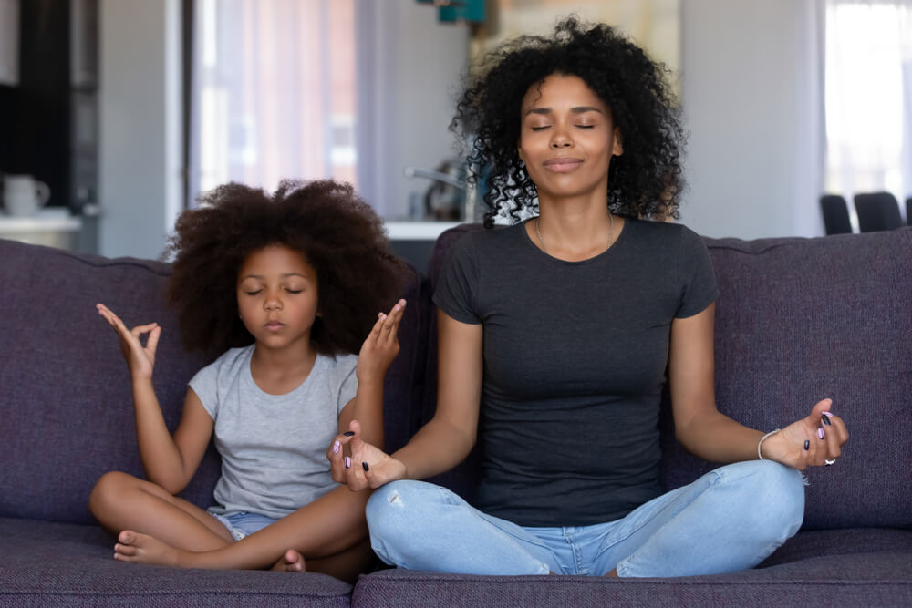 Madre e hija haciendo meditación.