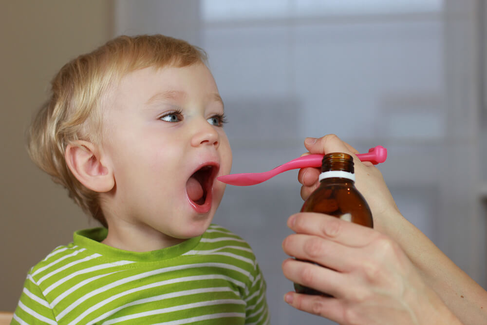 Mère donnant des médicaments à son fils.