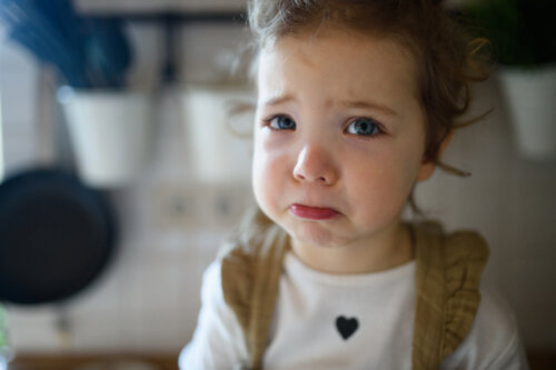 Niña triste durante el confinamiento porque no puede salir a jugar.