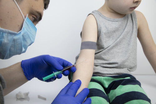 Médecin faisant une prise de sang sur un enfant.