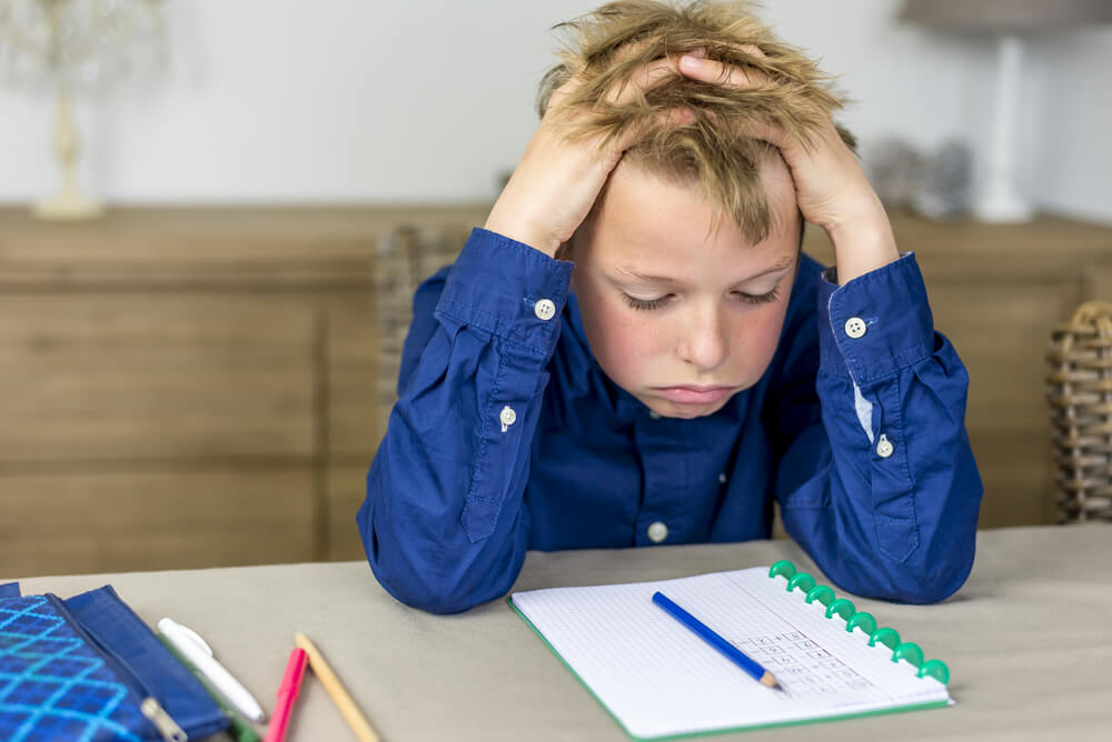 A child feeling stressed about his school work.