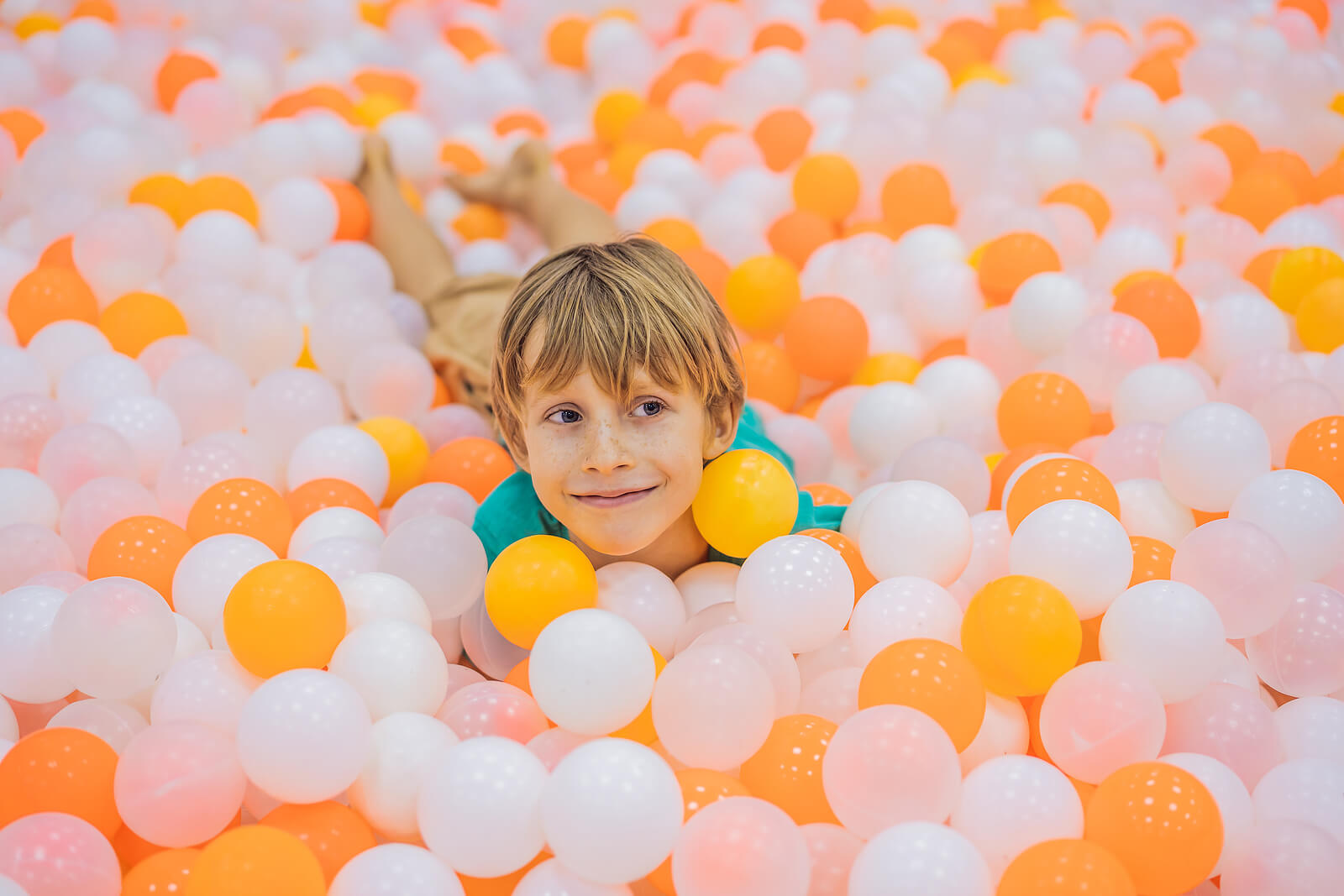 Niño jugando en un parque de bolas.