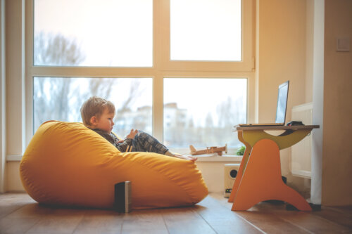 Niño sentando en un puff en su espacio de aprendizaje en casa.