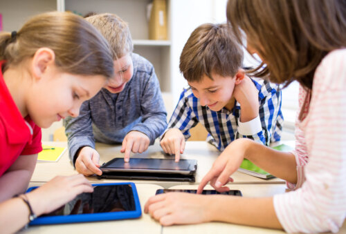 Niños con tablets usando la tecnología en el aula.