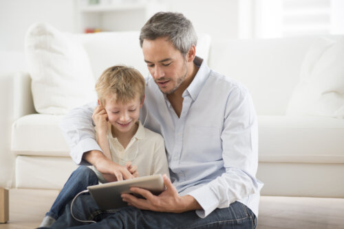 Padre enseñando a su hijo a usar las redes sociales con responsabilidad y enseñándole el valor de la discreción.
