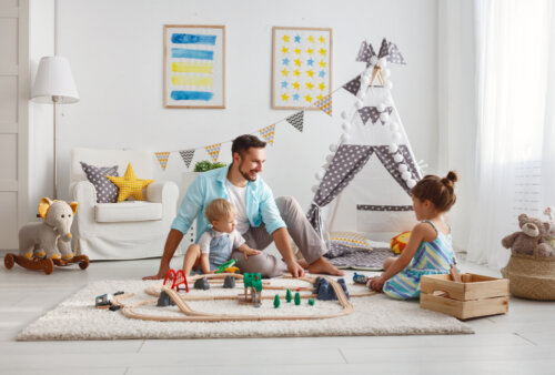 Padre jugando con sus hijos en el salón de casa.