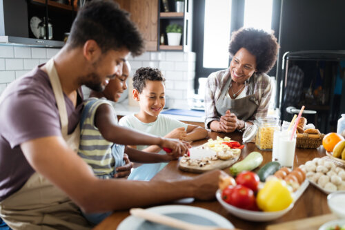 Familia cocinando y planificando un menú vegetariano y sano en familia.