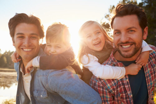 Deux adultes avec deux enfants qui sourient.