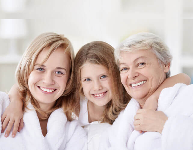 Grandmother, mother, and daughter posing for a picture.