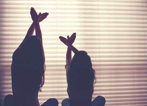 Madre e hija haciendo sombras con las manos.