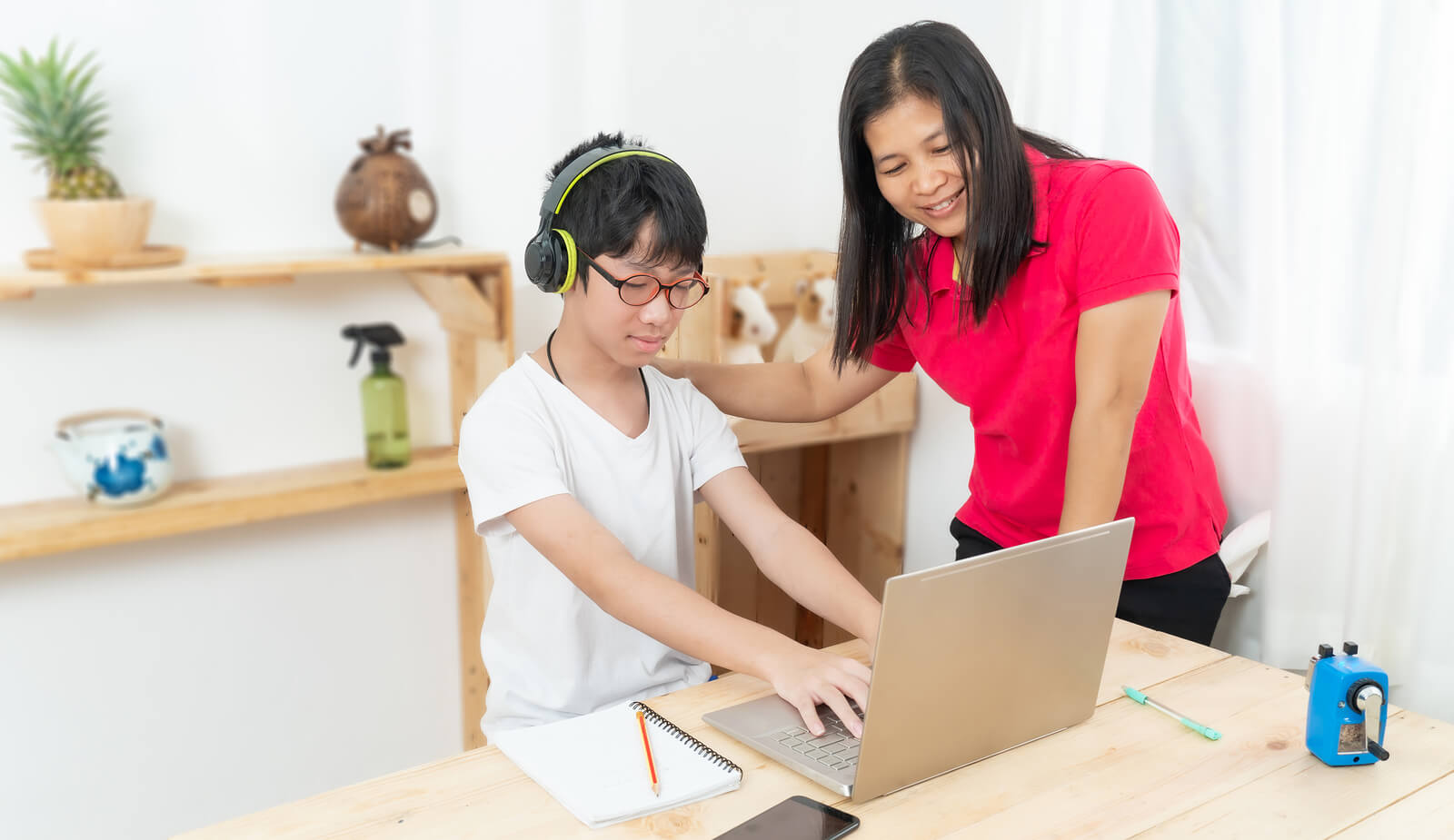 Madre dando consejos a su hijo para que aprenda mecanografía.