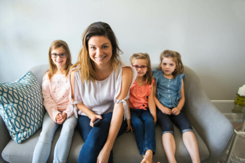 Madre soltera con sus hijas en el sofá.