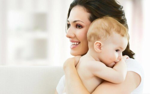 Mamá abrazando a su bebé durante siendo una madre suficientemente buena.