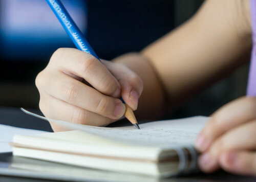 Niña escribiendo un diario de gratitud.