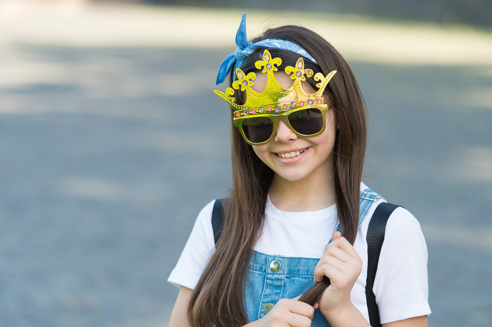 Niña con unas gafas y una corona.