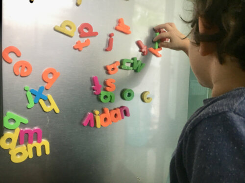 Niño llevando a cabo una de las actividades del método Montessori para aprender a leer y escribir.