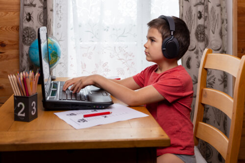 Niño con el ordenador aprendiendo mecanografía.