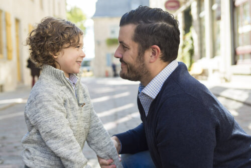 Padre hablando con su hijo en la calle.