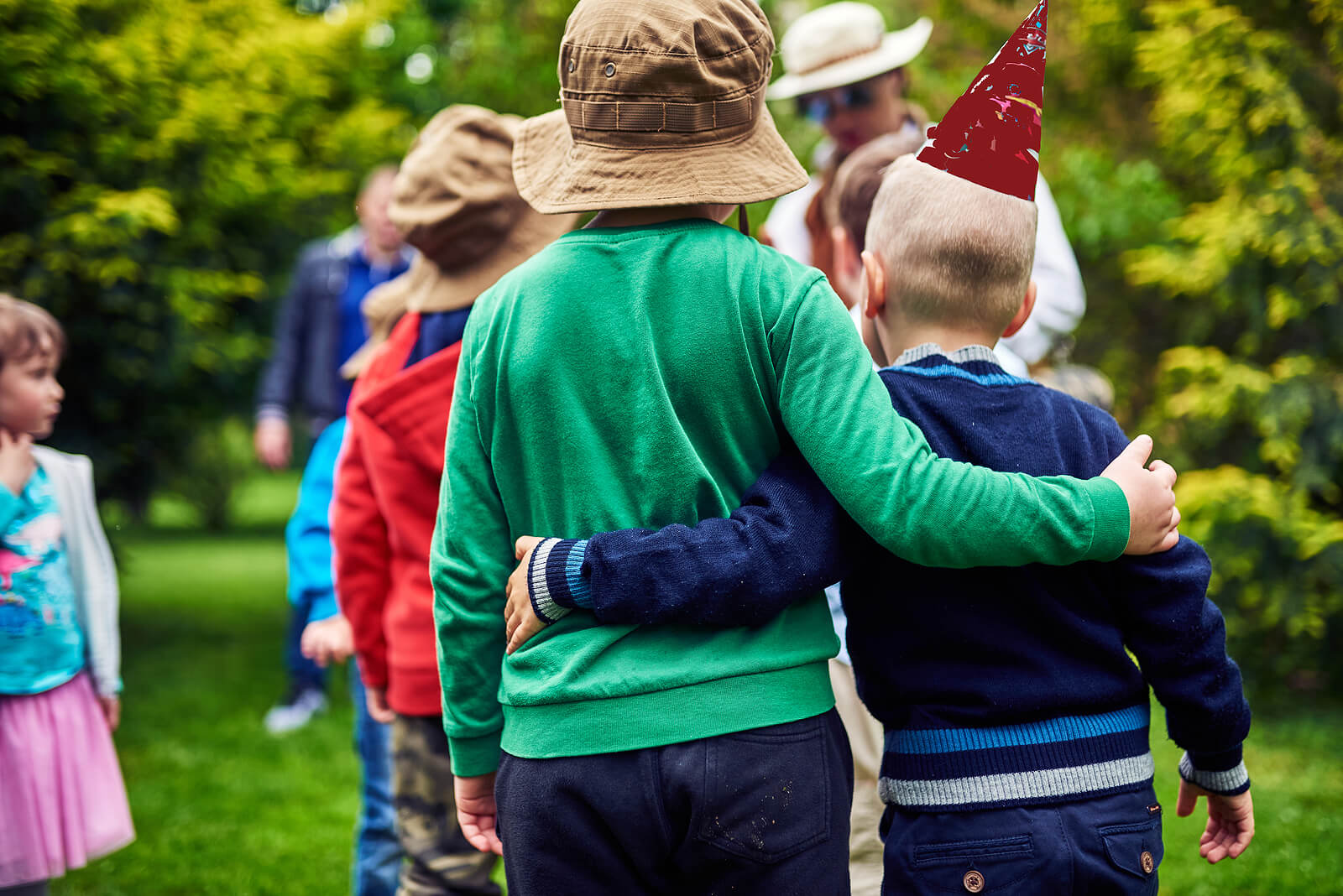Niños dándose un abrazo durante una excursión por el campo como parte de su desarrollo social.