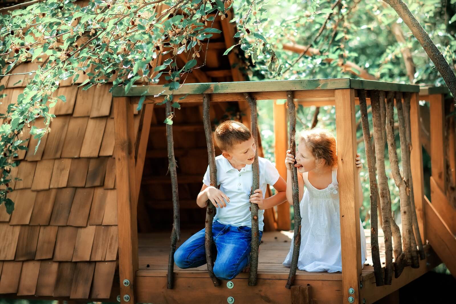 Niño jugando al escondite en la cabaña del bosque tras rifar antes de jugar.