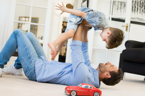 Padre jugando con su hijo en el salón de casa.