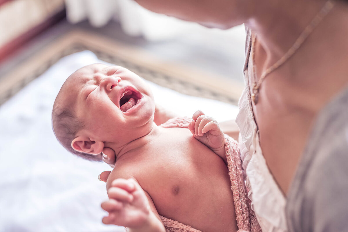 Mamá con su bebé en brazos porque llora y el cerebro de una madre se activa.