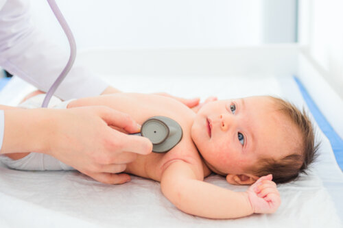 Pediatra escuchando el corazón de un bebé para comprobar que no tenga un soplo.