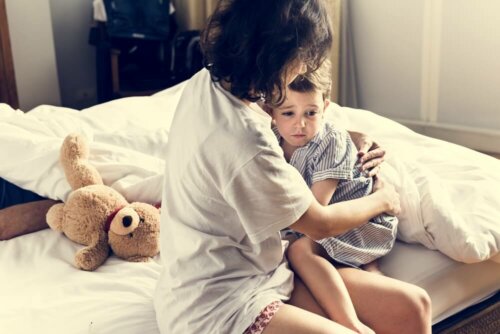 Madre abrazando a su hijo en la cama después de tener una pesadilla.
