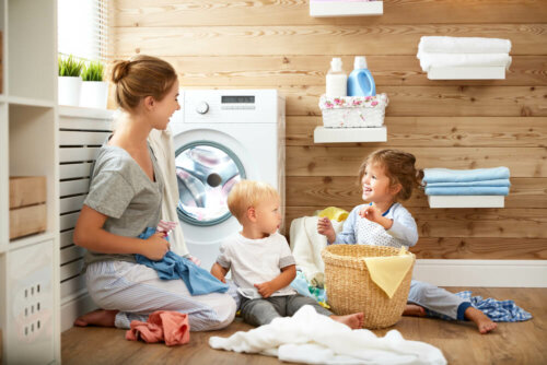 Mamá enseñando a sus hijos a poner una lavadora.