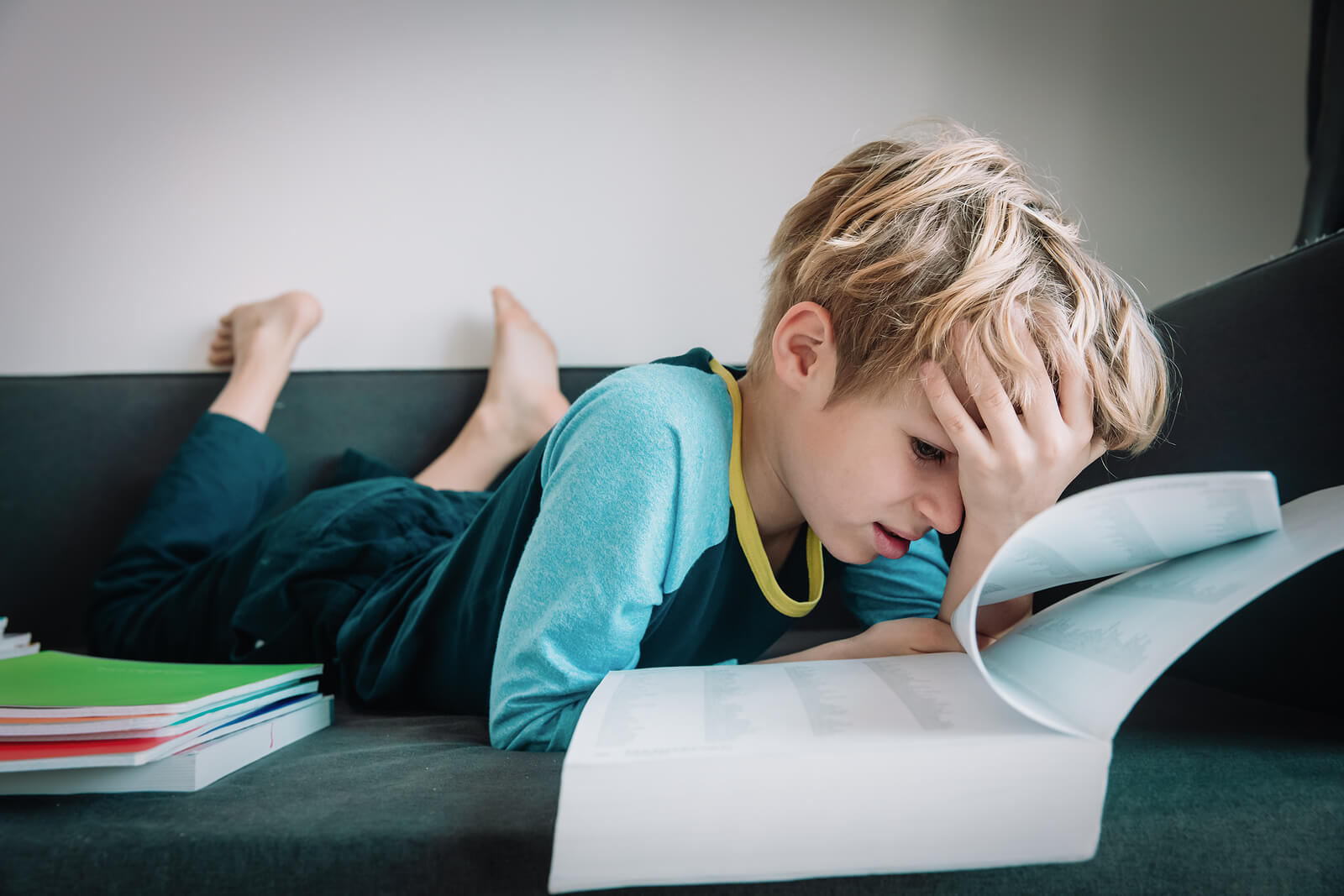 Niño con problemas de concentración intentando estudiar.