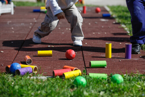 Niño jugando a los bolos en casa.