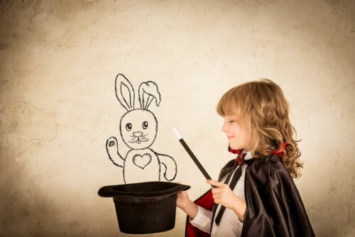 Niño sacando un conejo de una chistera mediante la magia.