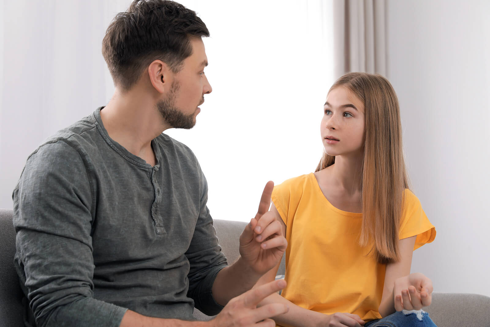 Padre hablando con su hija sobre las técnicas para afrontar las críticas en la adolescencia.