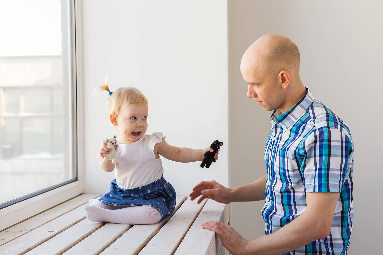 Papá con su hija hablando para estimular el balbuceo de los bebés.
