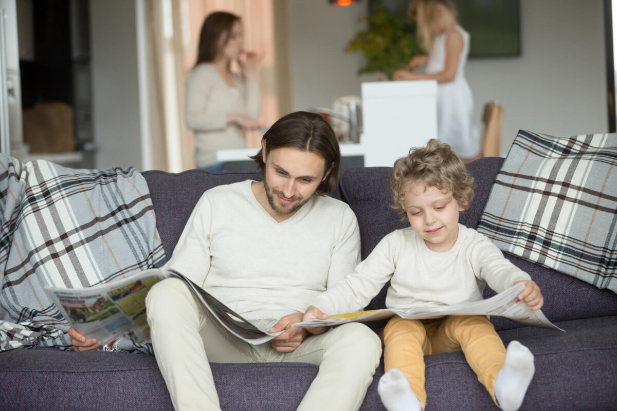 Padre e hijo leyendo el periódico como parte del juego imitativo.