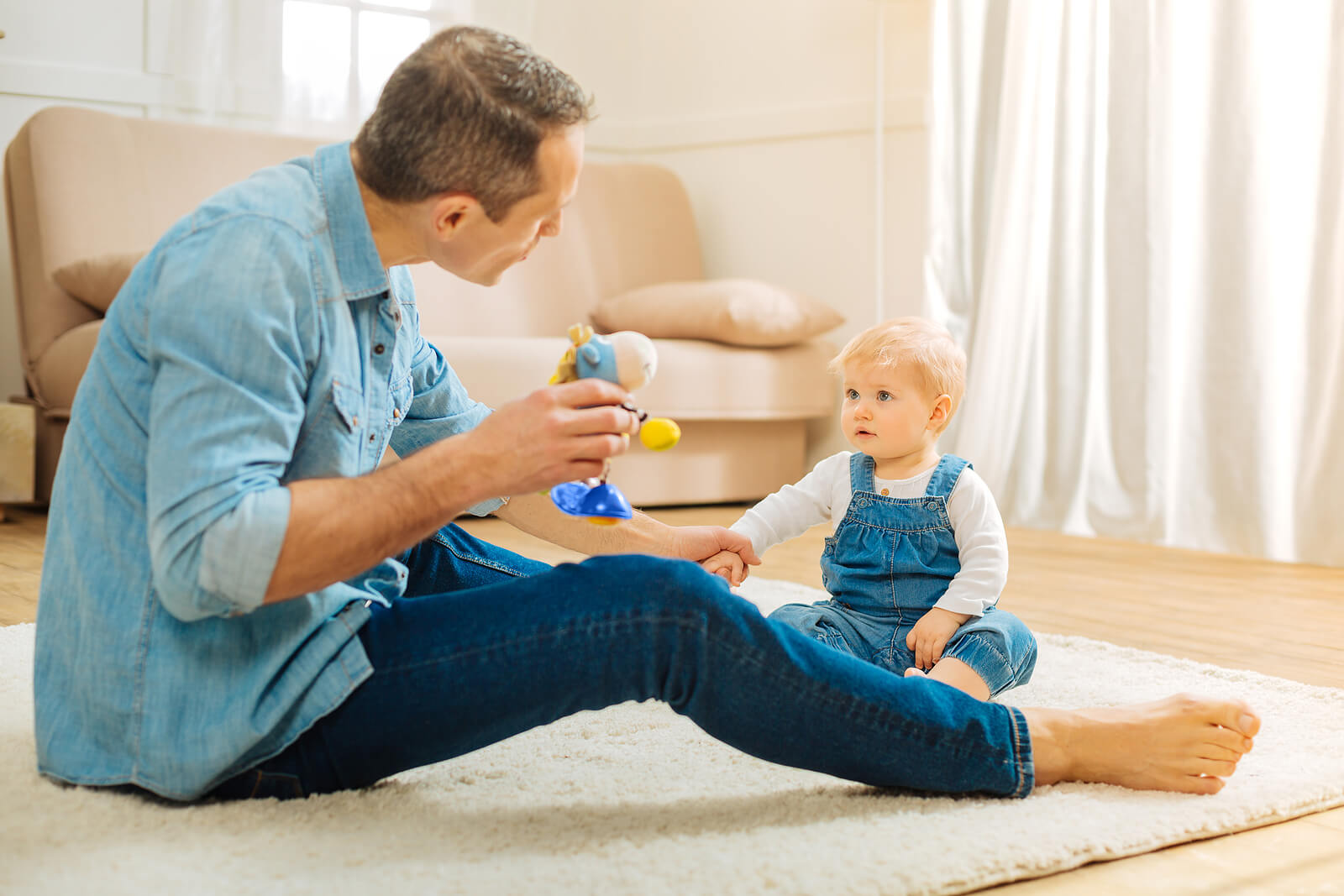 A father entertaining his child with a toy.
