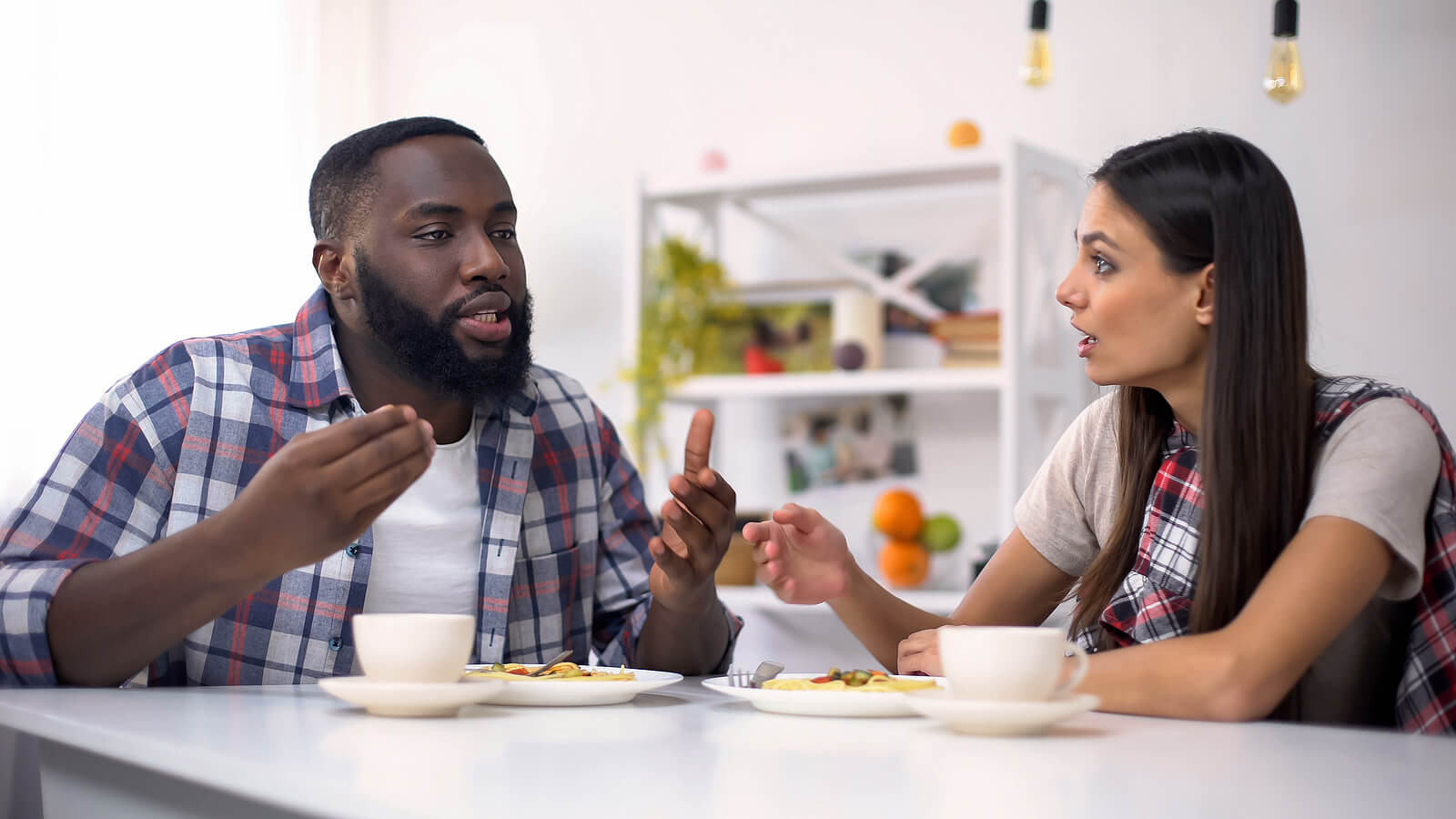 Pareja discutiendo durante el desayuno.