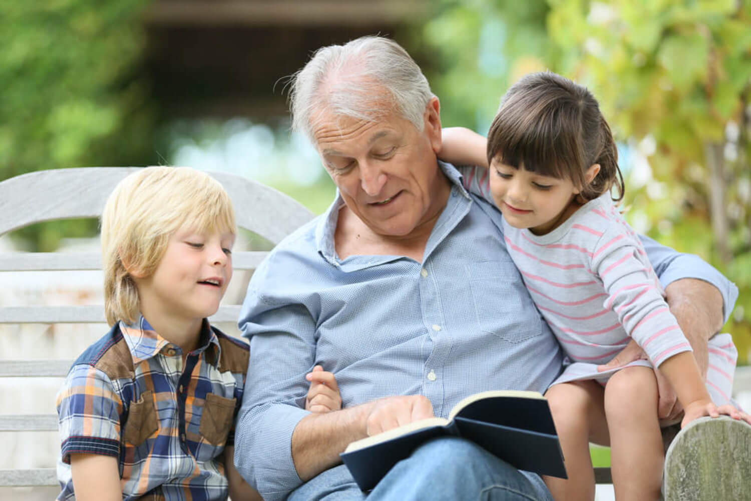 Abuelo leyendo un libro a sus nietos.
