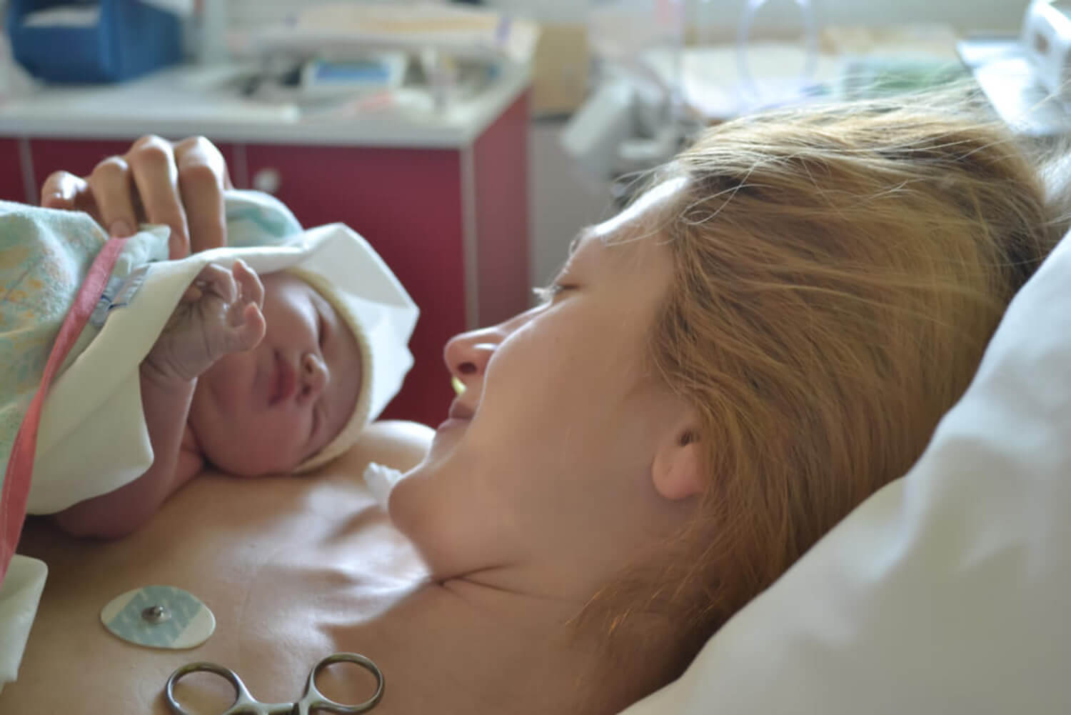 Madre con su bebé recién nacido en brazos tras sufrir sepsis neonatal.