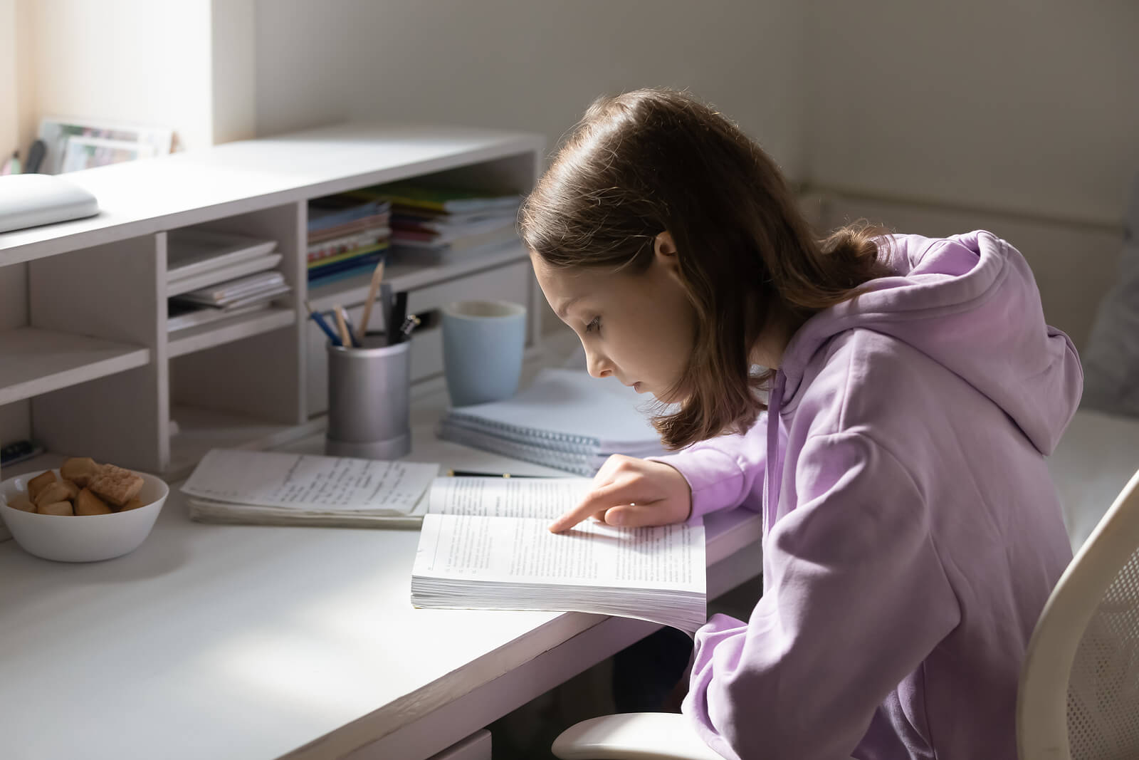 Chica adolescente en su cuarto estudiando.