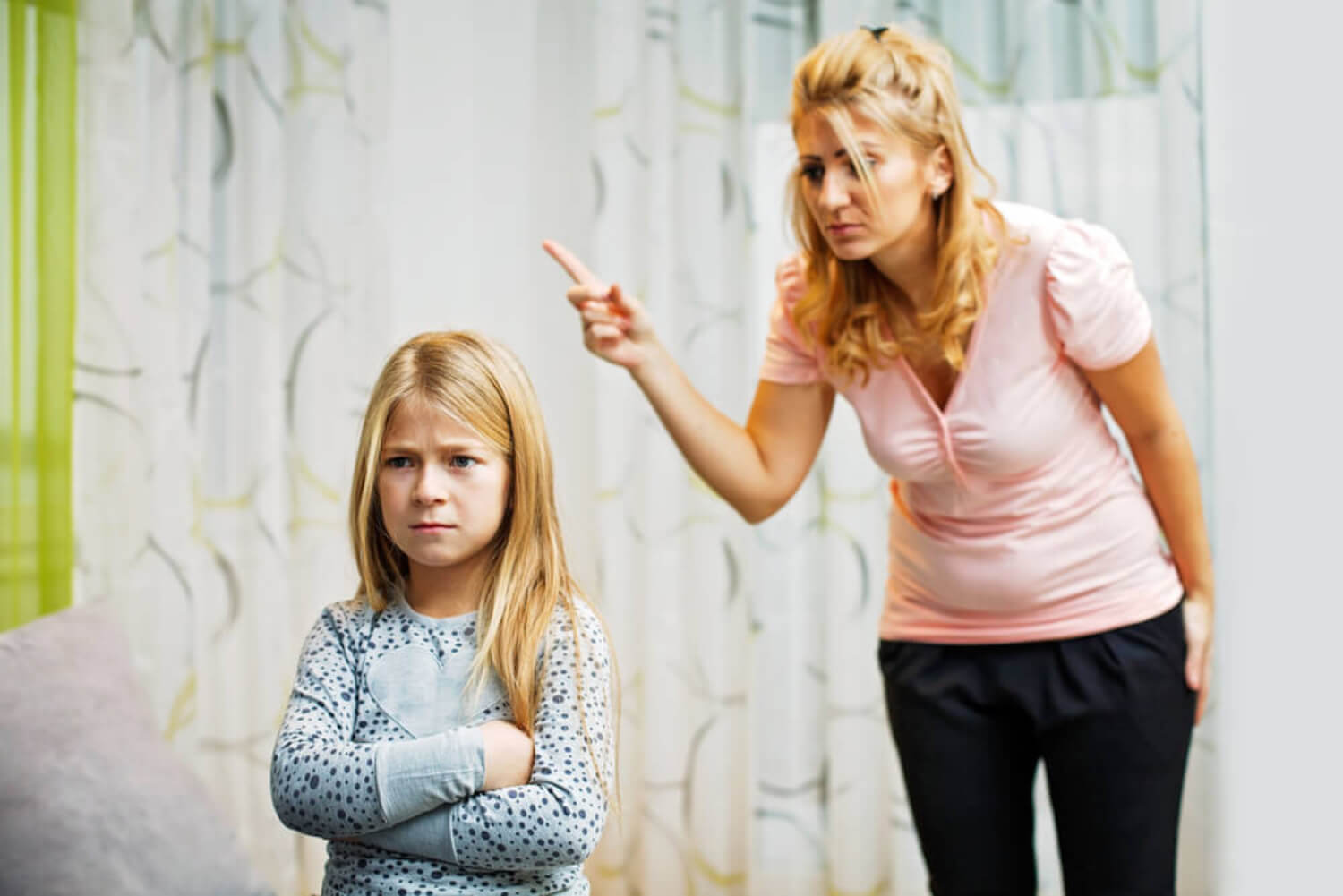 Madre con el dedo levantado castigando a su hija.