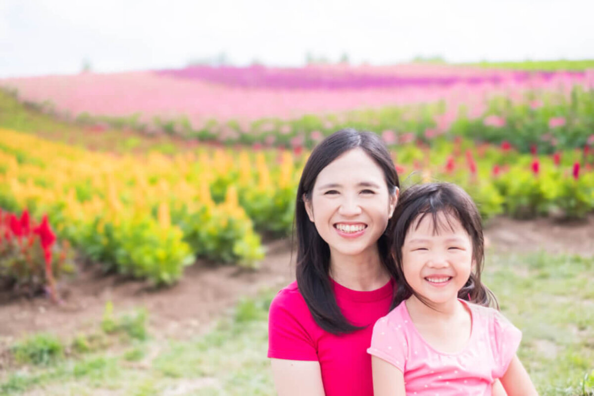 Madre e hija asiáticas en un campo de flores.