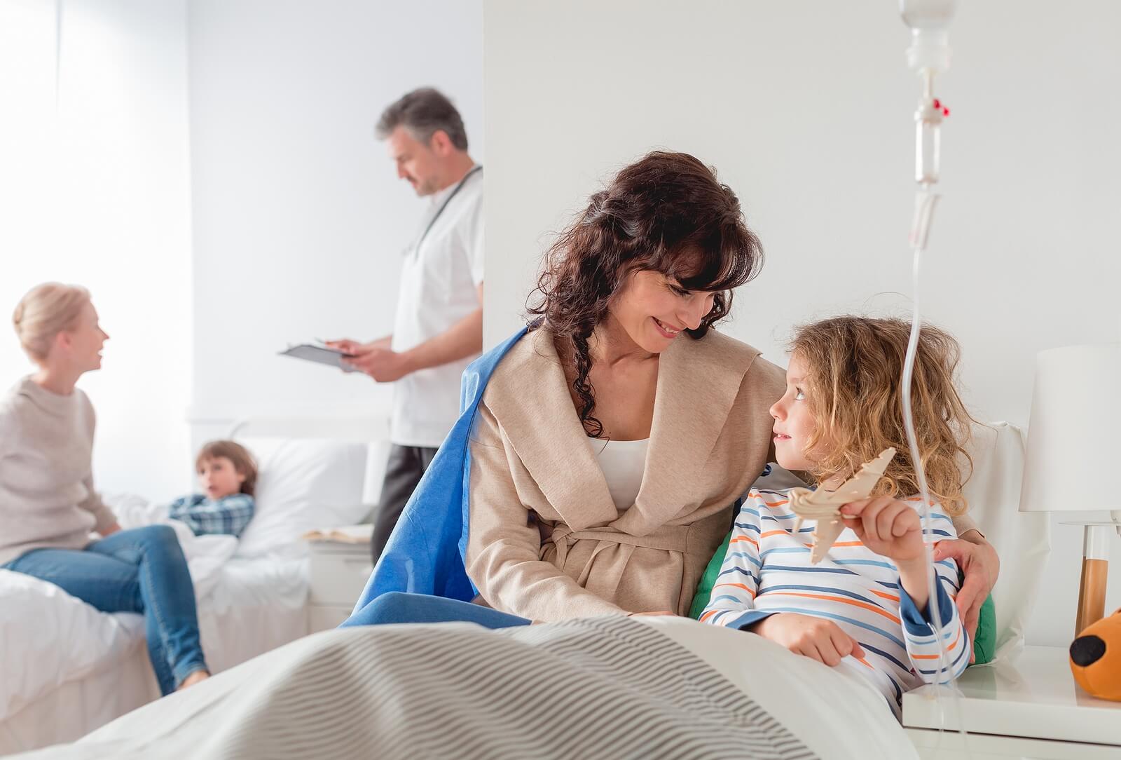 Madre con su hija durante el ingreso de su hermano enfermo en el hospital.