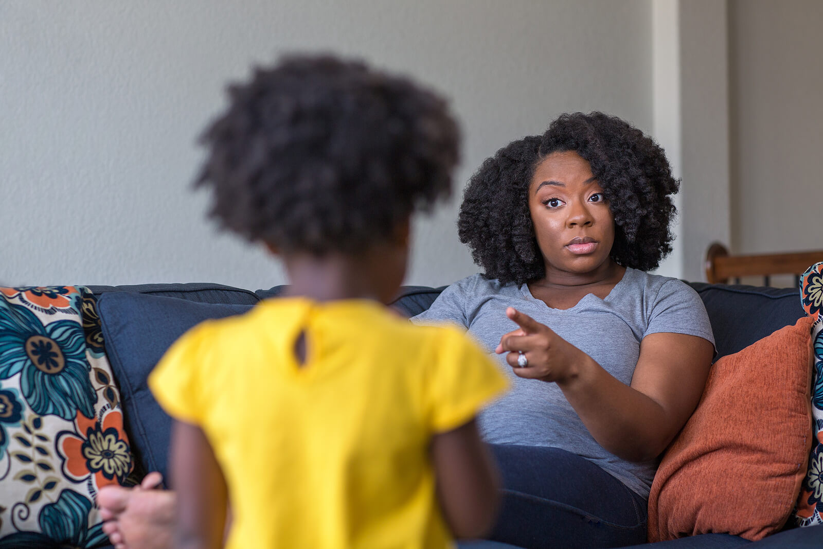 Madre regañando a su hija con problemas de disciplina.