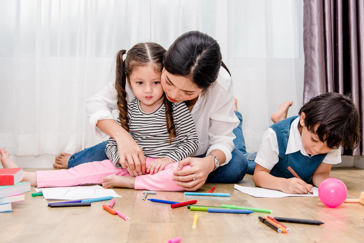 Madre pintando con sus hijas para poder analizar los dibujos de los niños según los colores que usan.